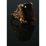 A 14ct gold dress ring set with a large faceted smoky quartz stone. Having rope twist shoulder