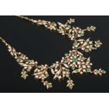 A gold, emerald and seed pearl necklace of bib form, having reticulated sections. Tests from 14ct to