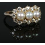 A yellow gold pearl and diamond cluster ring. Having three central pearls with 16 stone diamond