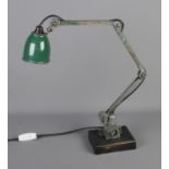 A mid 20th century industrial anglepoise lamp with green enamel shade on wooden base.