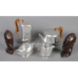 Four pieces of Piquotware teawares along with two wooden carved African busts. Includes teapot,