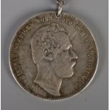 A Swedish 1868 silver coin on chain. 'Carl XV Sveriges Norr. Goth. Och Vend. Konung' to one side and