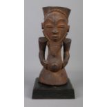 An early to mid 20th century wooden ancestor figure raised on wooden plinth. Probably of the Hemba