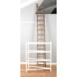 A large set of wooden extension ladders along with painted folding clothes horse.
