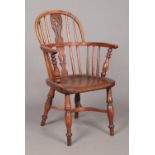 A 19th century child's ash/elm and yew wood Windsor arm chair with crinoline stretcher. Height of