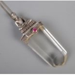 A Tibetan silver and quartz stone pendant on silver chain. Set with a single ruby. Formed as a