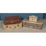 Four assorted vintage travel suitcases of various sizes.