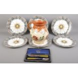 Six Wedgwood Etruria cabinet plates along with a pottery jug and a cased silver plated cutlery set.