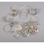 A collection of white metal costume jewellery including bangles, bracelets, novelty charms, etc.