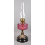 A Flash of Slough flamingo glass and brass oil lamp, on stepped circular base.