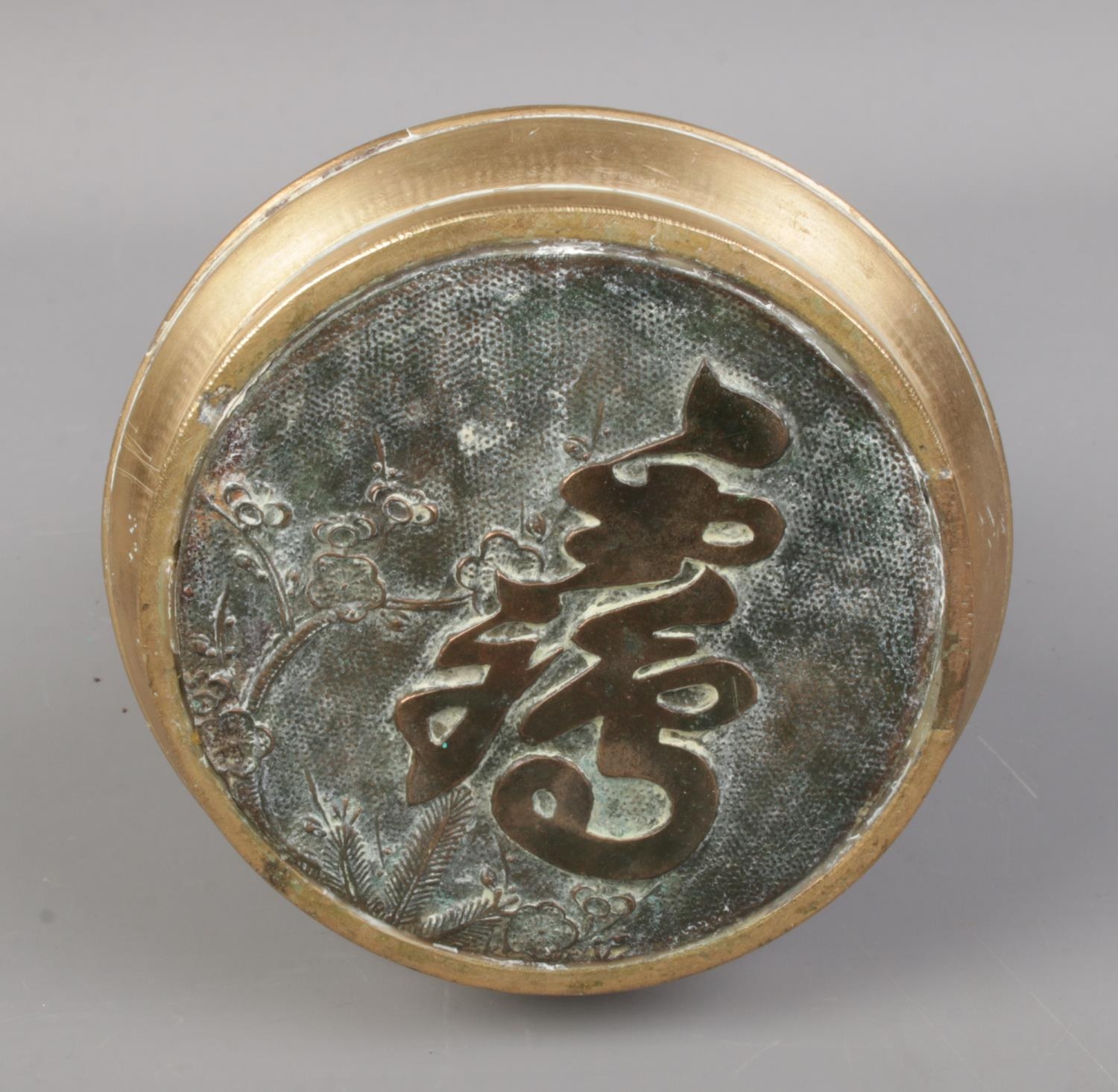 A Chinese brass seal featuring elephant head handles and floral decoration. - Image 2 of 2