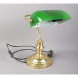 A vintage brass desk lamp featuring green glass shade.