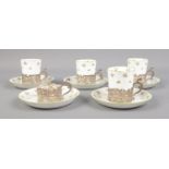 A set of Crown Staffordshire rosebud cups and saucers with William Comyns & Sons Ltd silver holders.