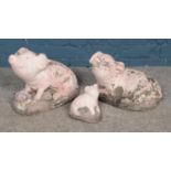 A set of three reconstituted stone painted pigs