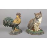 Two cast iron door stops in the form of a cockerel and cat.