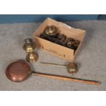 A box of metalwares to include copper bed pan, brass paraffin lamp, horse brasses, etc.