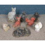 A collection of eight reconstituted stone animals including dog, cat and dove
