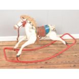 A vintage painted metal child's rocking horse.