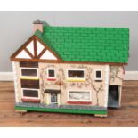 A child's painted two story wooden dollhouse raised on castors and fitted with handles to side.