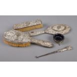 A collection of silver and silver mounted items. Includes hand mirror, two brushes, button hook