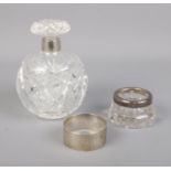 Two silver rimmed cut glass vanity items along with continental silver napkin ring. Hallmarks