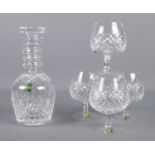 A Waterford crystal 'three ring' decanter, together with four Waterford crystal brandy glasses.