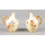 A pair of Royal Worcester blushware jugs decorated with poppies, bluebells and gilt handles. 13cm