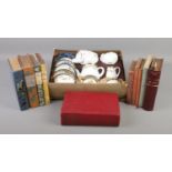 An early 20th century boxed childs/dolls tea set along with a collection of books.