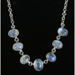 A silver necklet set with seven cabochon moonstones. Tested.