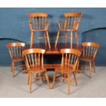 An oval pine table with twin pedestal base together with folding hideaway leaf and six chairs.