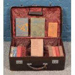 A vintage suitcase containing an assortment of antique and vintage books. To include 'Ivanda A