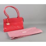 A red Radley handbag, with pink dust bag. Some slight signs of wear to the corners.