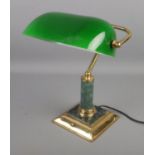 A vintage brass desk lamp with green glass shade.