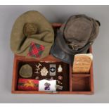 A hinged box containing an assortment of military items. To include Royal Army Ordinance Corps