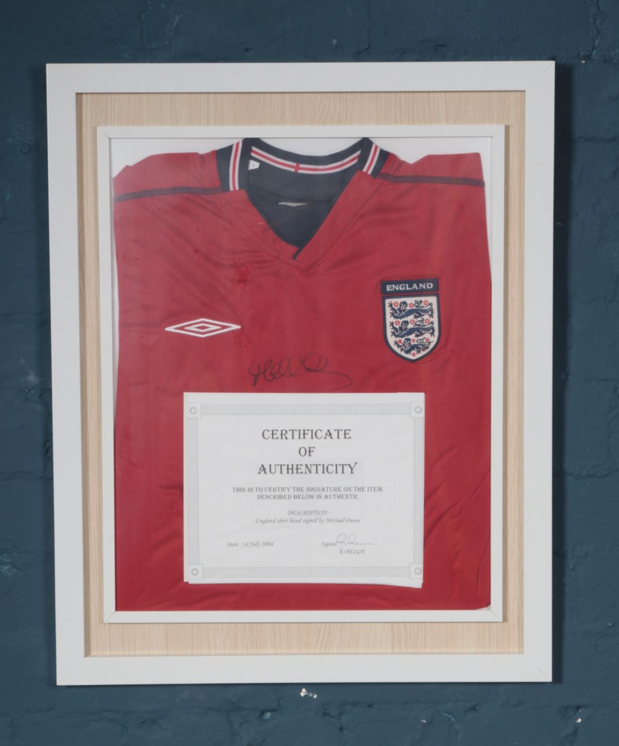 A framed England football shirt signed by Michael Owen with certificate of authentication