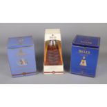 Two boxed Bell's extra special old scotch whisky decanters along a Millennium 2000 Bell's extra