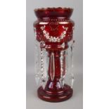 A Bohemian ruby glass lustre with clear glass droplets and gilt and floral detailing. 32cm high.