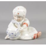 A Zsolnay figure of a child with jug. 7.5cm tall.