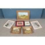 A collecting of artwork including etchings depicting a cat and a street view, an oil on board