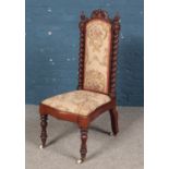 A Victorian carved mahogany prayer chair with carved decoration and barley twist columns.