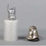 A Rover Viking car mascot along with similar mascot in the form of a fireman's helmet.