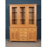 A modern oak cabinet with illuminated top and glass shelving. Height 201cm Width 147cm Depth 46cm