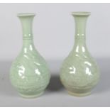 A pair of 19th century Chinese Celadon vases, decorated with dragons. Cracks and repairs to both