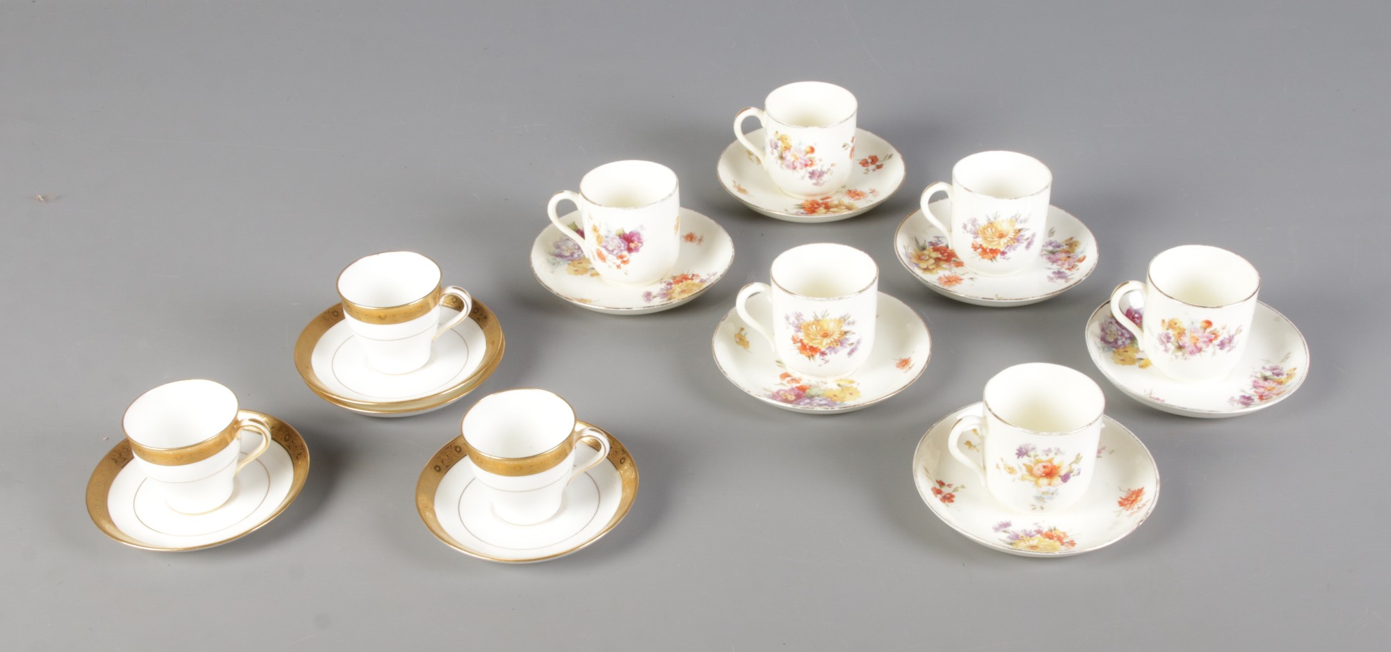 A collection of Davis Collamore & Co for Minton tea cups and saucers featuring gilt decoration.