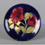 A Moorcroft Pottery cobalt blue hibiscus design plate. Diameter 26cm