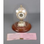 A quartz ostrich egg, hand painted, mantel clock cased in plastic dome. includes certificate of