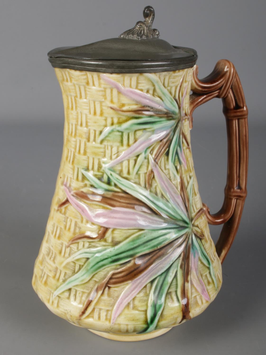 A Victorian majolica jug with pewter lid. Mark dated 1876 to the base. (20cm)