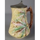 A Victorian majolica jug with pewter lid. Mark dated 1876 to the base. (20cm)
