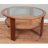 A mid century teak circular coffee table with glass inset top and bergÃ¨re lower tier. Diameter (