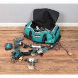 A large Makita carry bag with a quantity of power tools including nail gun, drills, jigsaw, angle